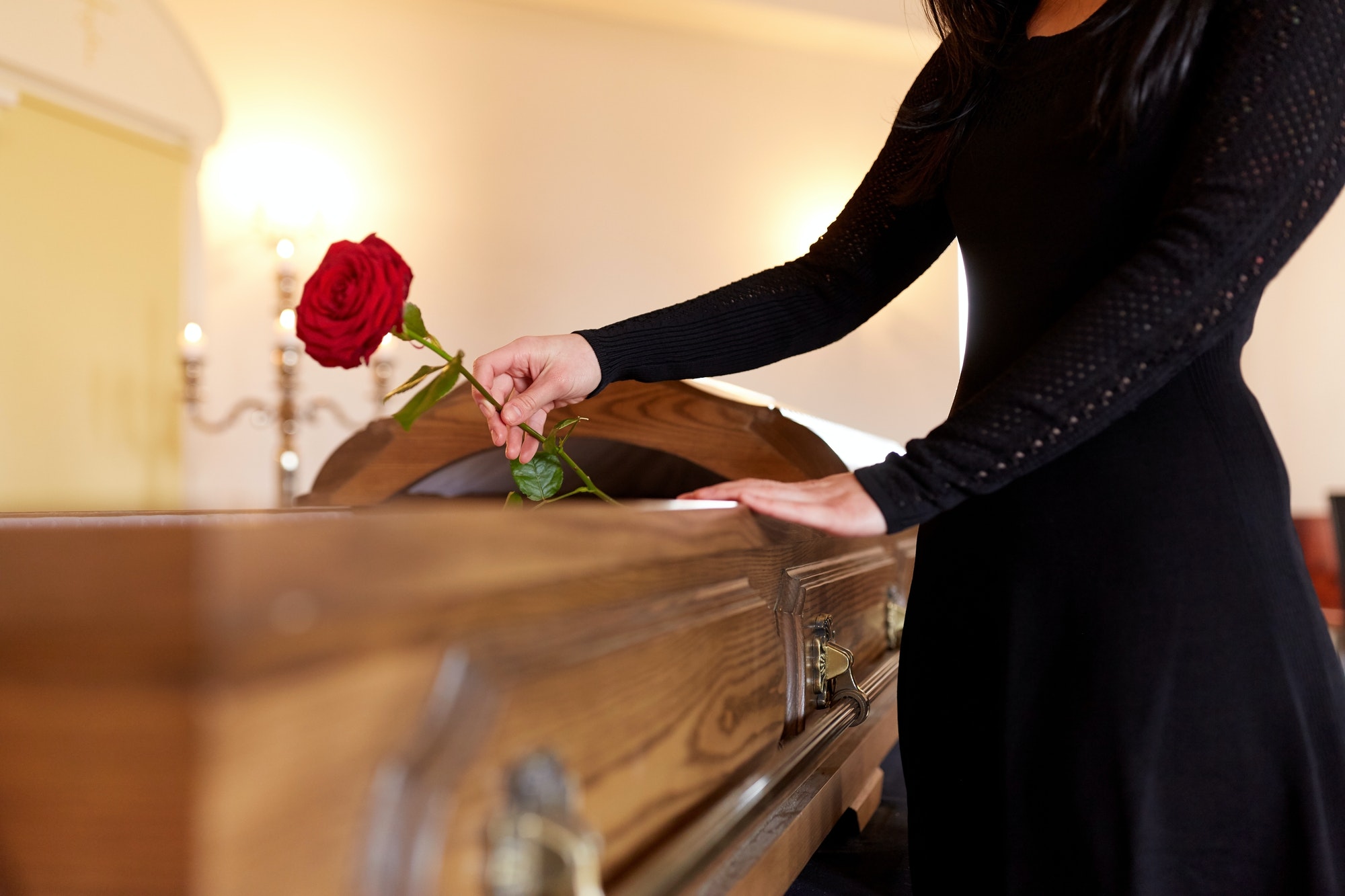 woman-with-red-roses-and-coffin-at-funeral.jpg